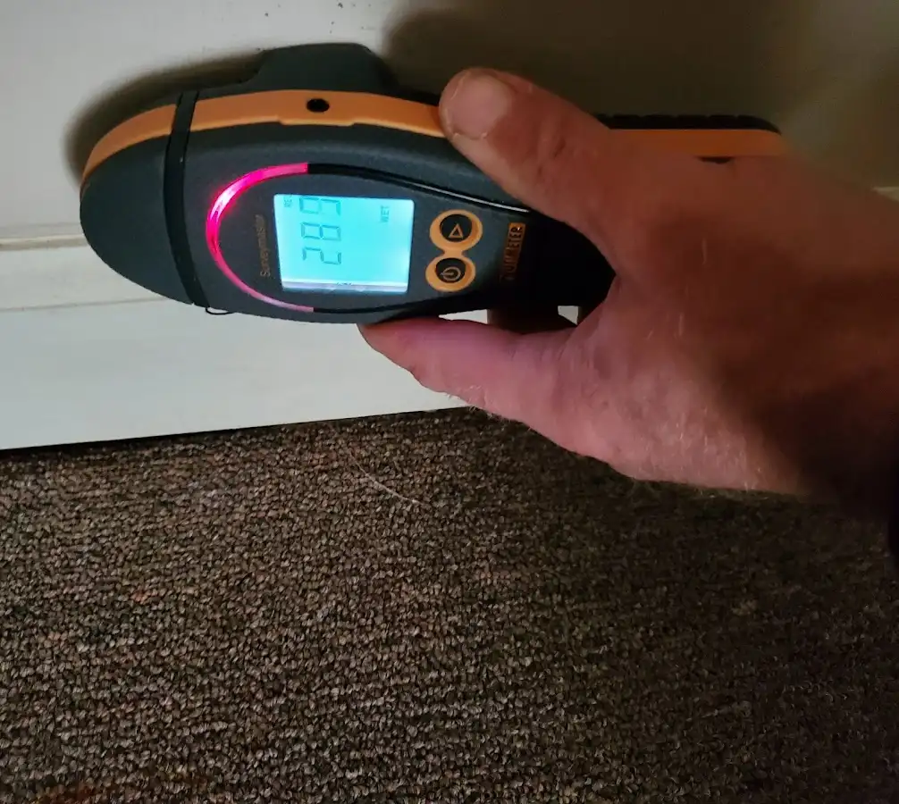 Moisture detection at baseboard during Storm Damage Restoration in Inkster